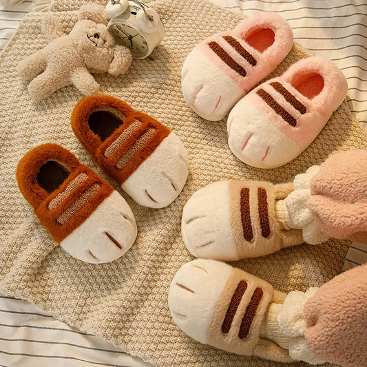Fluffy cat paw slippers for women in pink, brown, and beige on a cozy blanket with a plush bear