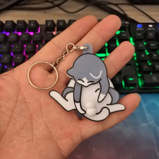 Hand holding a cute cat keychain in front of a RGB mechanical keyboard