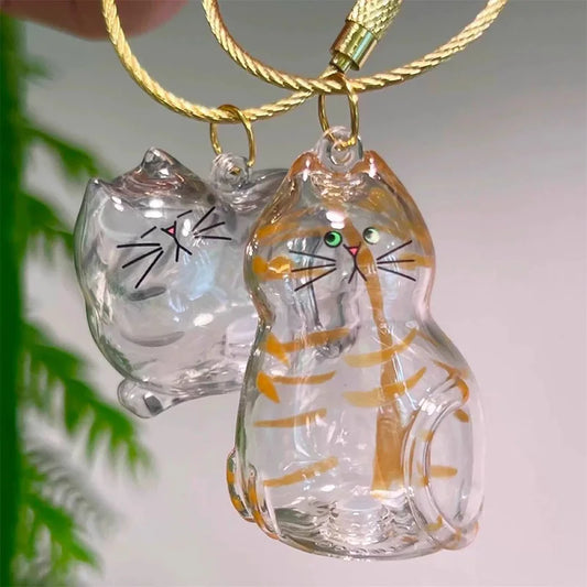 Glass cat keychains with gold stripes and whiskers on gold cords, close up